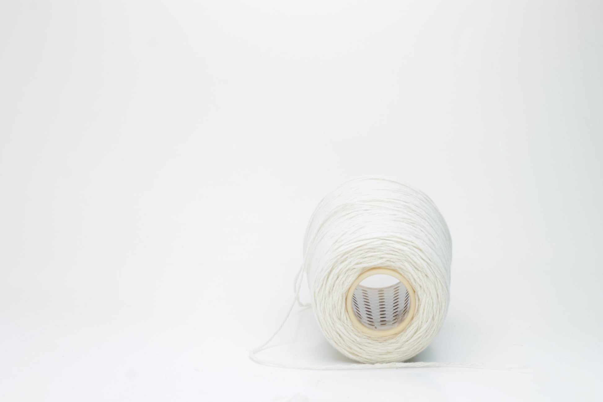 Single-ply, exceptionally fine cashmere yarn in a soft, undyed natural cream hue with a subtle, silky sheen and gentle fluffiness.