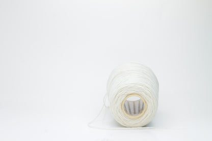Single-ply, exceptionally fine cashmere yarn in a soft, undyed natural cream hue with a subtle, silky sheen and gentle fluffiness.