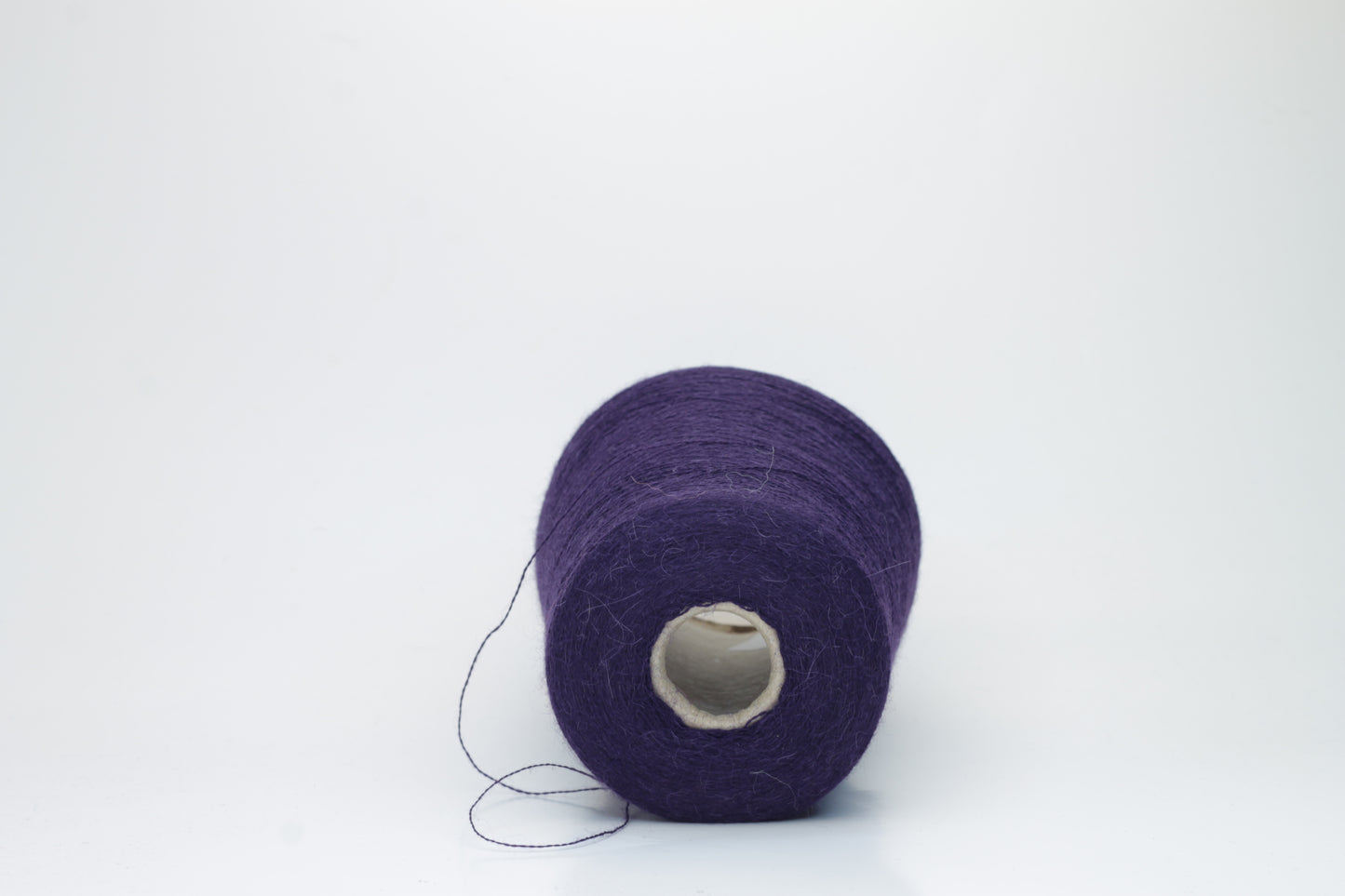 Rich purple 2-ply Alpaca Merino yarn, softly twisted with a gentle halo and subtle sheen, showcasing its deep, luxurious color saturation.
