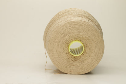 Close-up of a single strand of lustrous, fine-gauge beige silk and cotton yarn, showcasing its smooth, even twist and soft sheen.