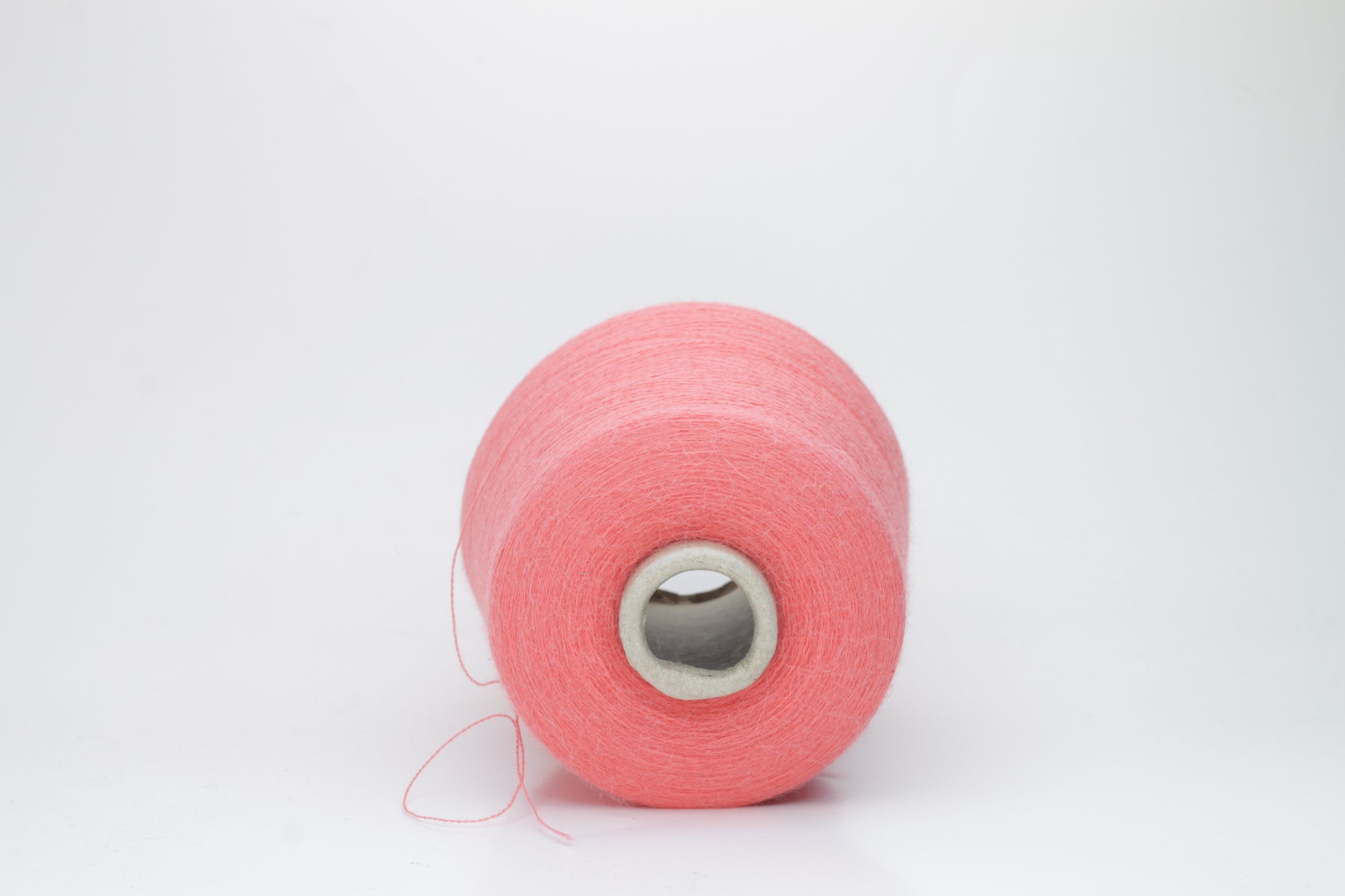 Coral 2-ply Alpaca Merino yarn, softly twisted with a gentle halo and subtle sheen, showcasing its deep, luxurious color saturation.