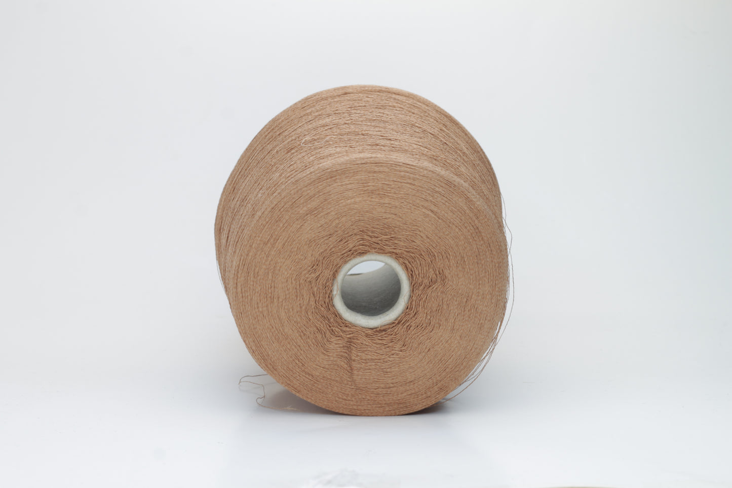 A finely spun, single-ply yarn in an earthy light brown hue, showcasing a delicate, rustic texture and a subtle, natural matte sheen.