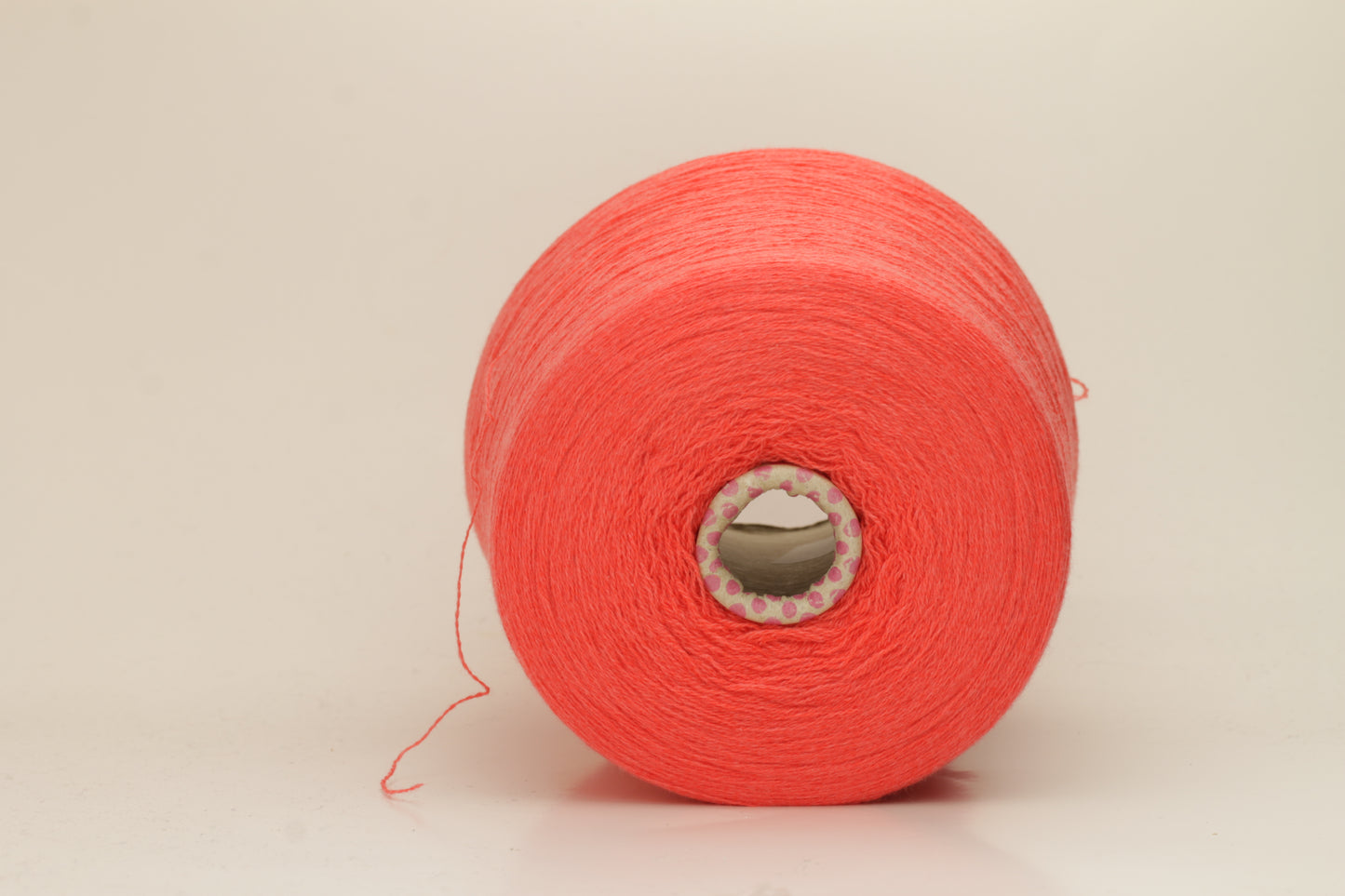 Luxurious two-ply cashmere yarn in vibrant coral (Corallo), showcasing a soft, subtle twist, smooth texture, and elegant natural sheen.