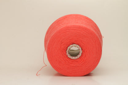Luxurious two-ply cashmere yarn in vibrant coral (Corallo), showcasing a soft, subtle twist, smooth texture, and elegant natural sheen.