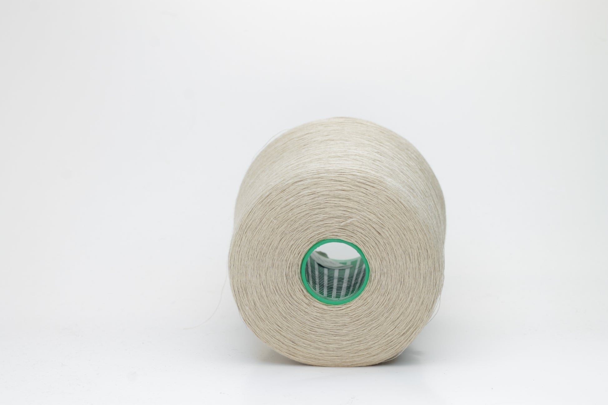 Fine, single-ply linen yarn in a rich Oatmeal. Reveals a crisp texture and subtle natural sheen, typical of pure linen fiber.