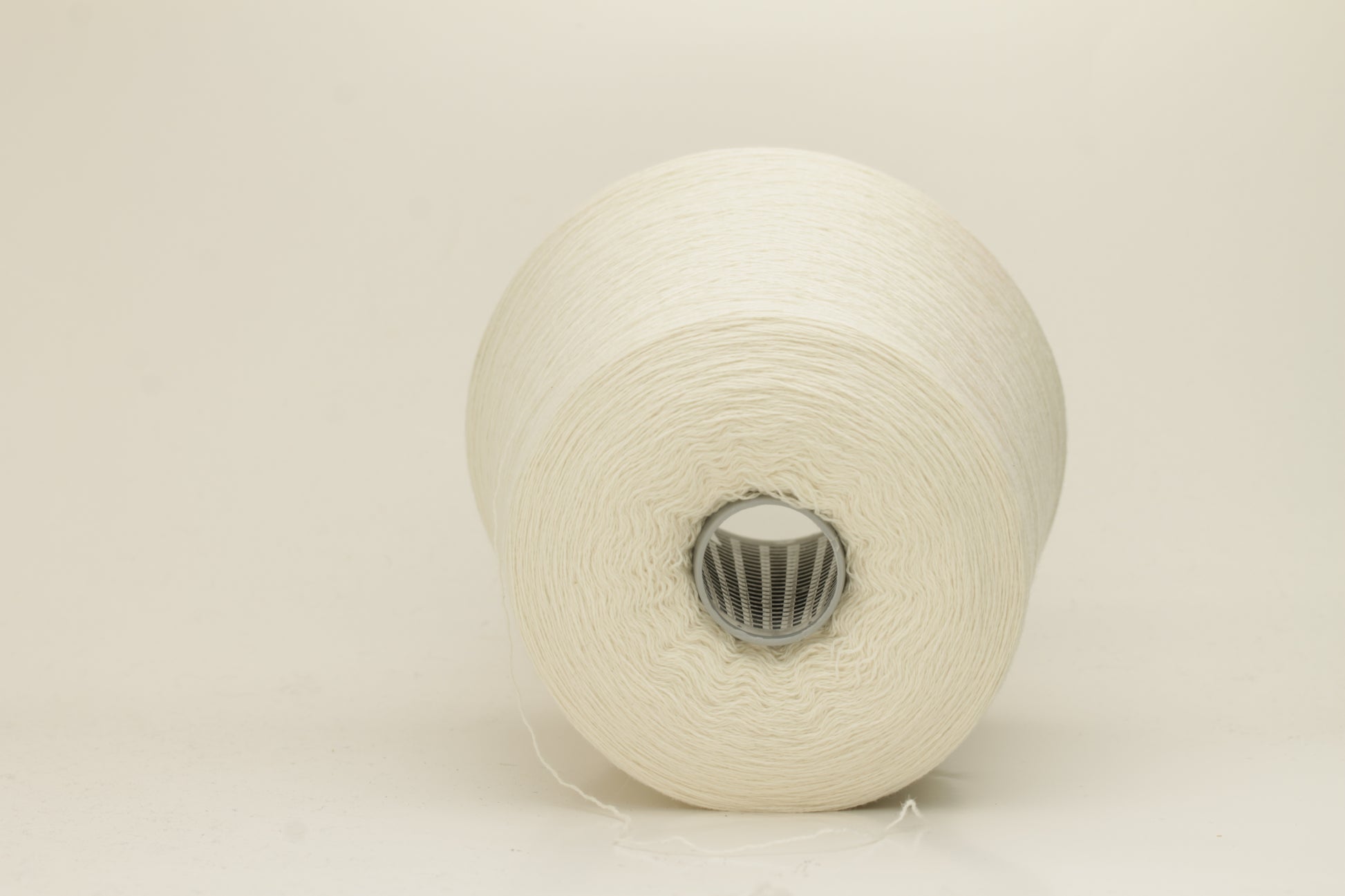 Close-up of a skein of pristine Ice White 100% cashmere yarn, showcasing its fine, evenly plied two-ply structure and delicate, soft halo.