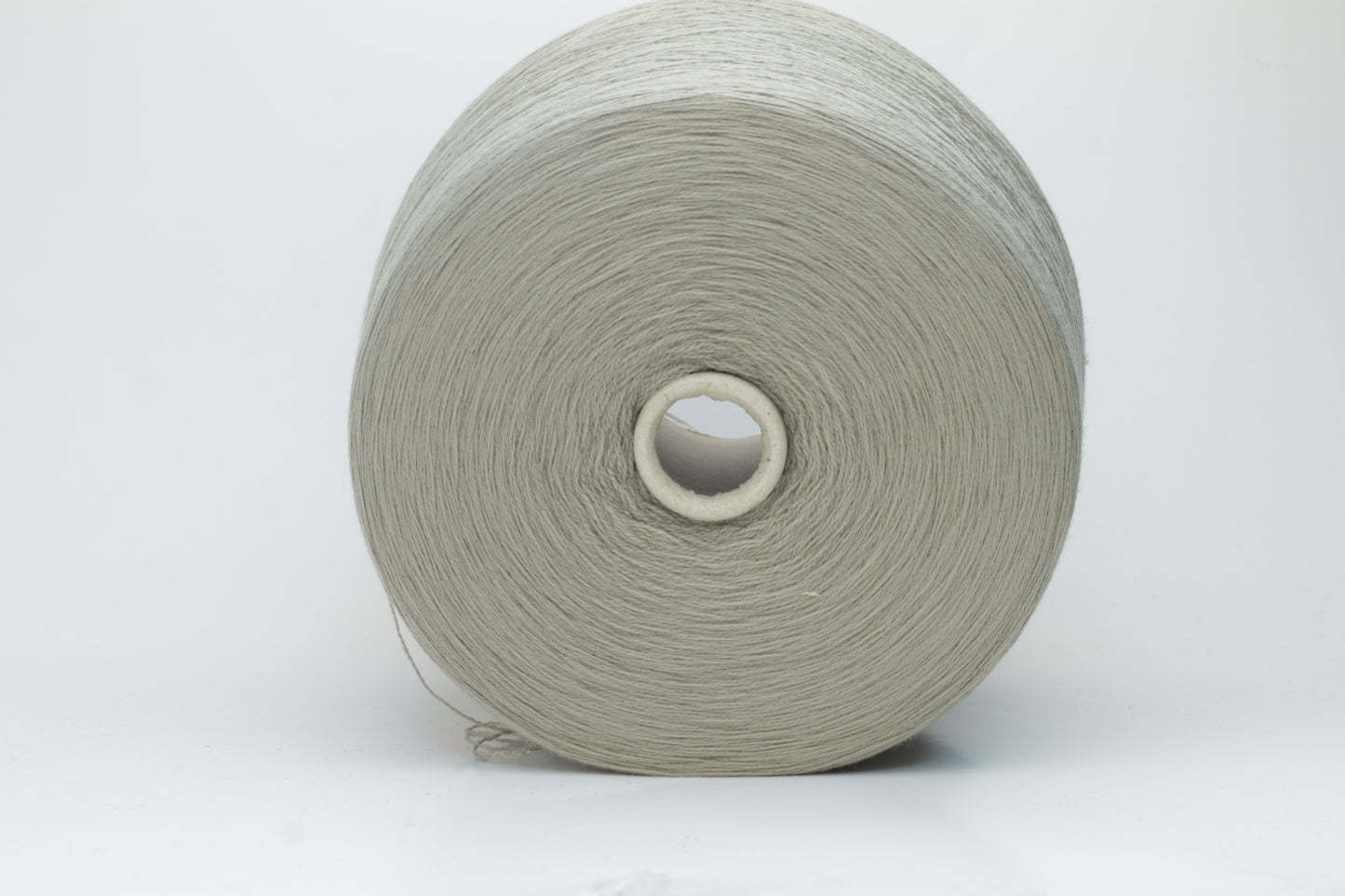Close-up shot of the grey merino yarn, showcasing its fine 2/30 ply twist and subtle sheen, with a fluffy texture revealed through careful lighting.