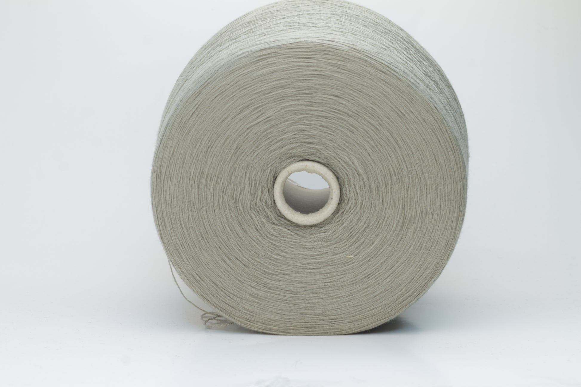 Close-up shot of the grey merino yarn, showcasing its fine 2/30 ply twist and subtle sheen, with a fluffy texture revealed through careful lighting.