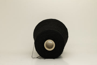 Close-up of a Black, textured Nodino yarn, showing subtle, irregular nubs and a soft, matte sheen; twisted ply visible.