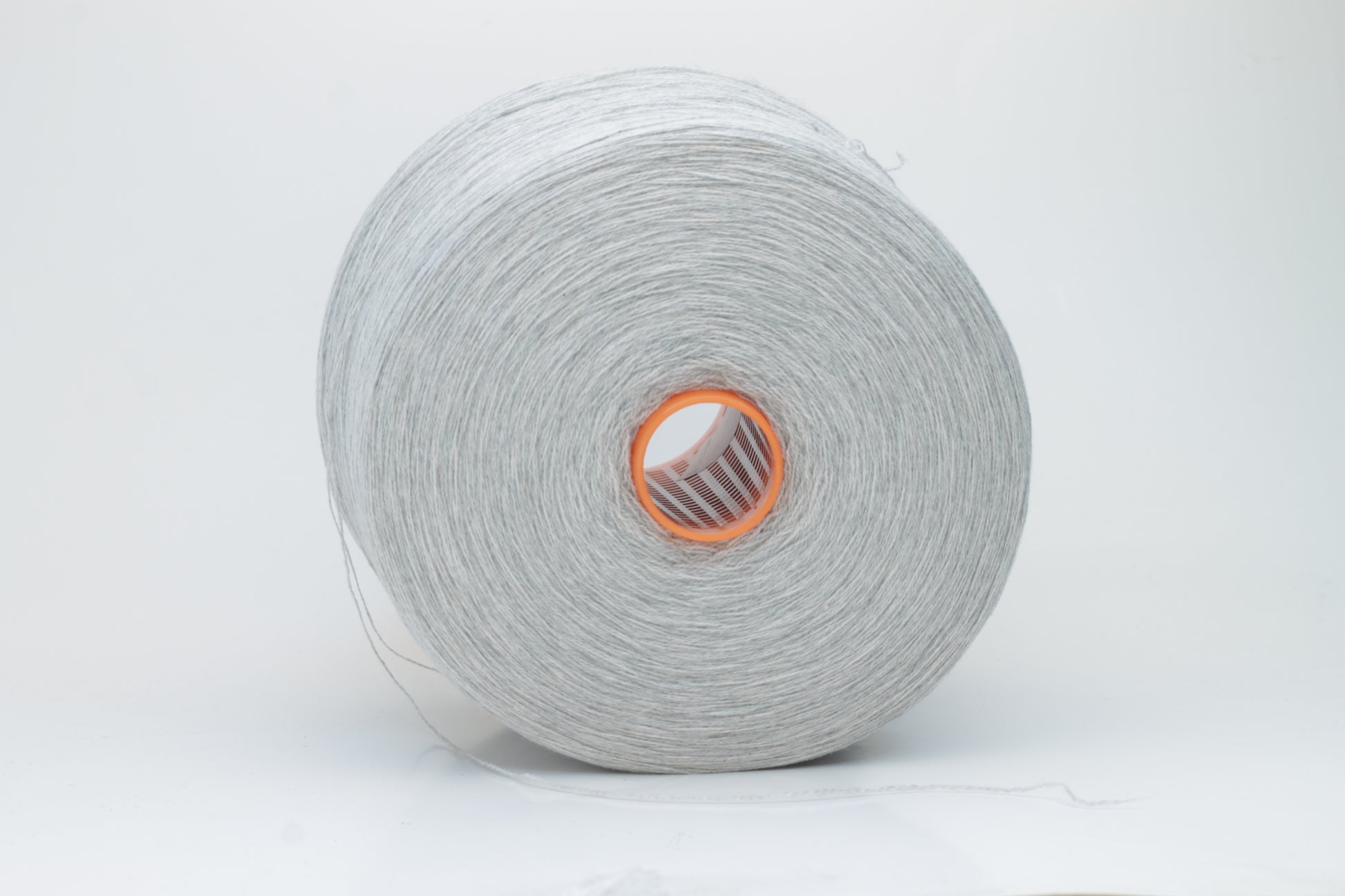 Close-up of a skein of luxurious, soft gray 100% cashmere yarn, featuring a gentle halo and a subtle, refined sheen. The two-ply structure is visible, showing even twist and consistent depth of the elegant cool gray color.