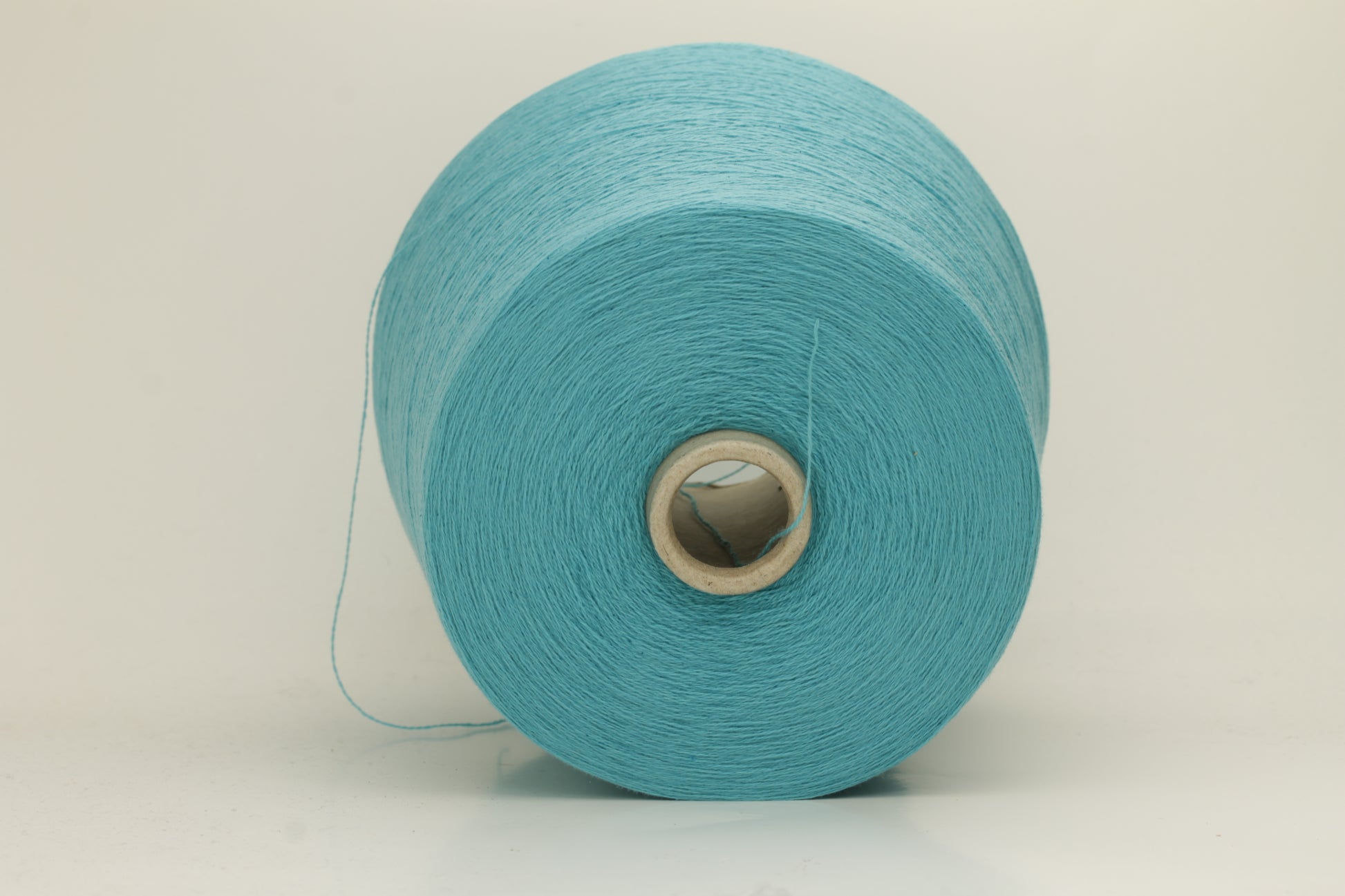 Close-up of a vibrant bright turquoise cashmere yarn hank, showcasing its fine, soft 2-ply twist and subtle, luxurious sheen.