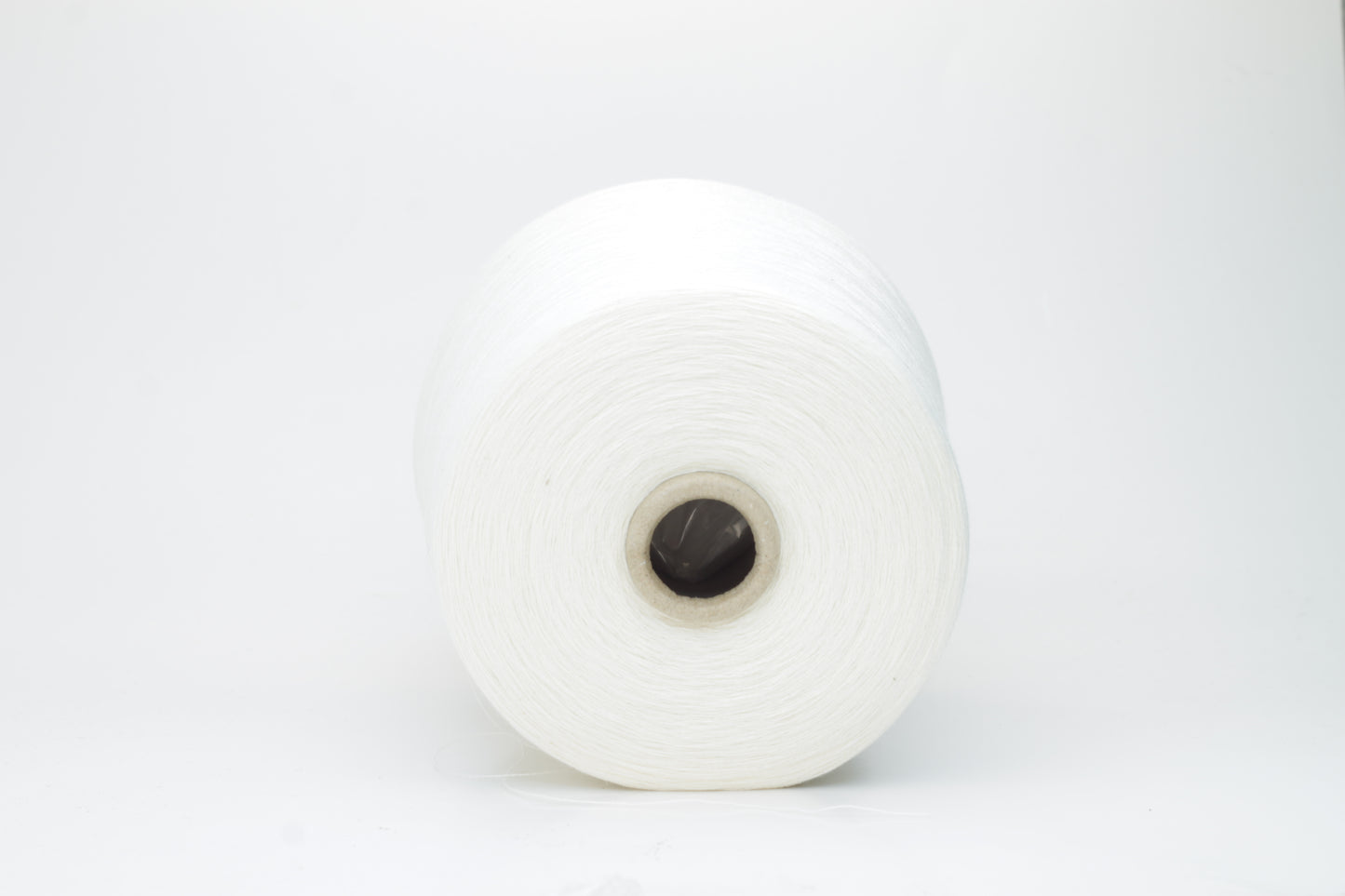 Close-up view of a creamy white, fluffy yarn strand with subtle sheen. The yarn shows a twisted ply construction and a dense, luxurious texture, hinting at its high cotton and cashmere fiber content.