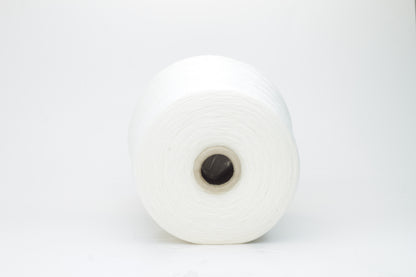 Close-up view of a creamy white, fluffy yarn strand with subtle sheen. The yarn shows a twisted ply construction and a dense, luxurious texture, hinting at its high cotton and cashmere fiber content.