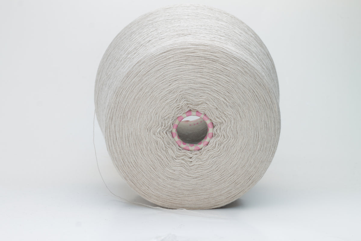 Close-up shot of a vibrant, creamy beige merino yarn skein, showcasing its subtle sheen, delicate ply twist, and the fine, soft texture of the fibers.