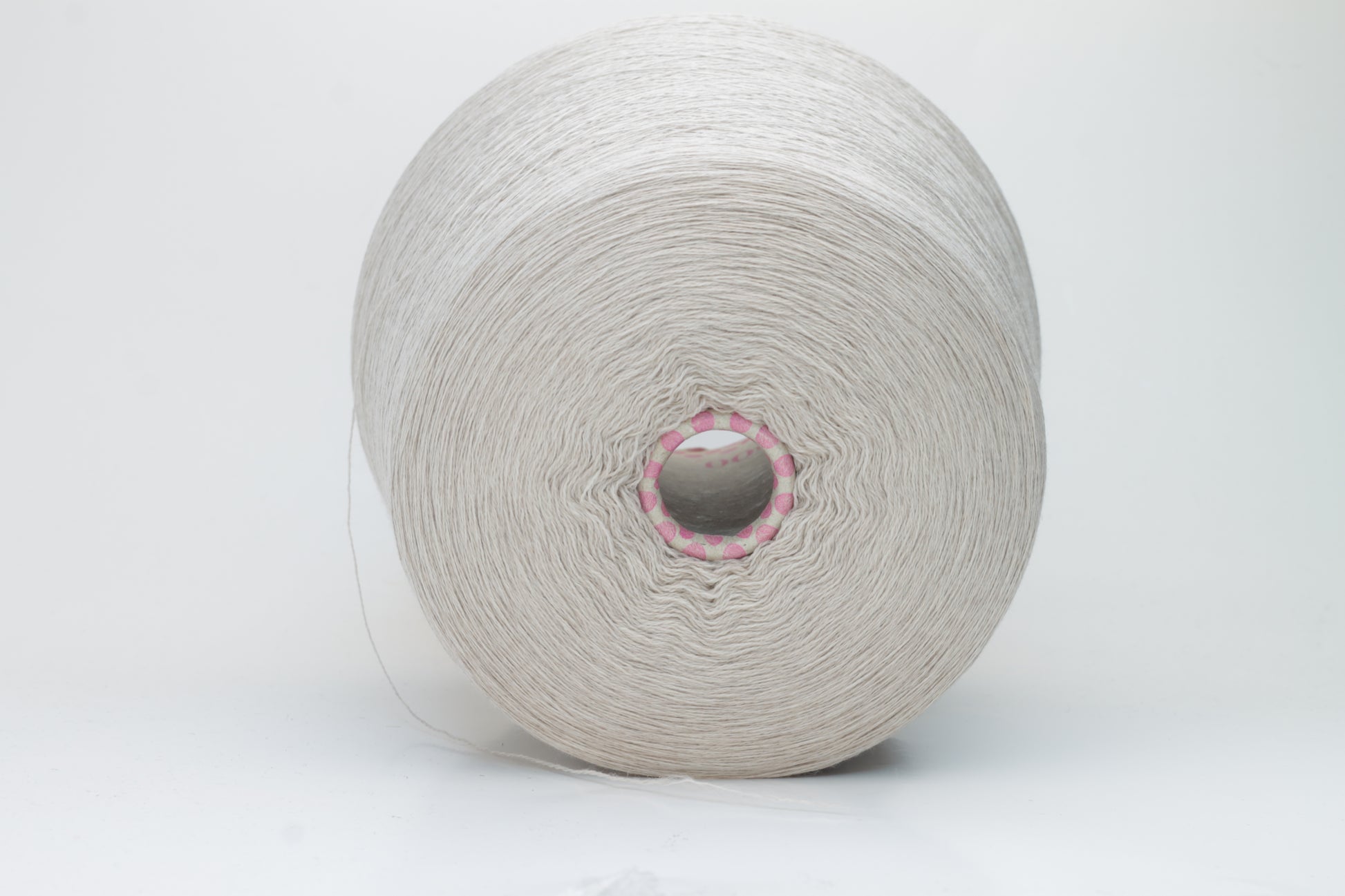 Close-up shot of a vibrant, creamy beige merino yarn skein, showcasing its subtle sheen, delicate ply twist, and the fine, soft texture of the fibers.