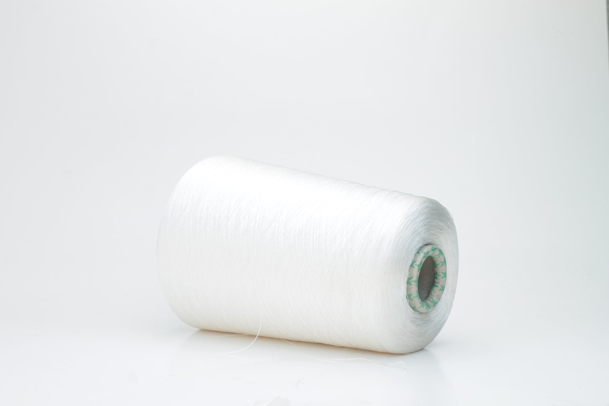 Close-up of brilliant white 100% silk yarn, single-ply strand with a smooth, highly lustrous surface, softly draped. Shimmering.
