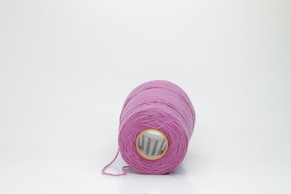 A beautifully wound cone of fine, single-ply cashmere yarn in a soft wisteria purple hue, displaying a delicate halo of fluff and subtle sheen.