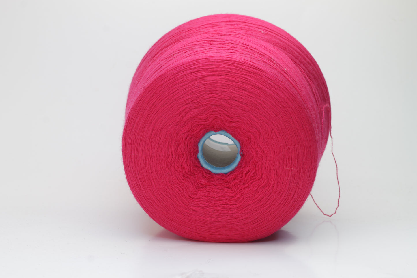 Close-up of vibrant fuchsia 100% merino yarn, showcasing a tight ply twist and a dense, fluffy texture with subtle sheen, perfect for intricate knit designs.