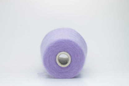 Close-up of fluffy Lila kid mohair and silk blend yarn, subtly lustrous with a soft halo, gently twisted into a fine, delicate thread.