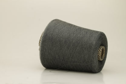 Close-up of a luxurious, finely spun two-ply cashmere silk blend yarn in a soft, elegant gray shade with a subtle sheen, showcasing its delicate texture.
