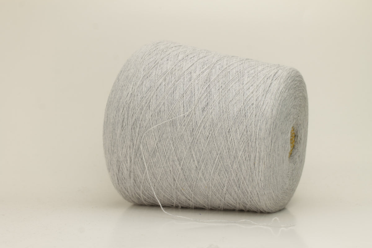 Close-up of a two-ply, fine gauge cashmere yarn in a soft, ethereal misty grey-blue hue with a subtle halo and gentle sheen.