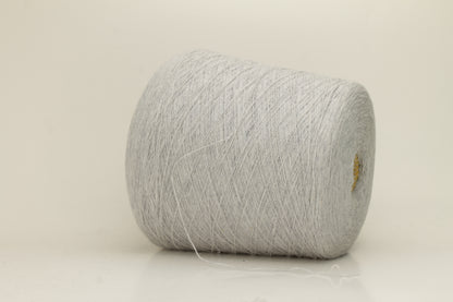 Close-up of a two-ply, fine gauge cashmere yarn in a soft, ethereal misty grey-blue hue with a subtle halo and gentle sheen.