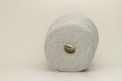 Close-up of a two-ply, fine gauge cashmere yarn in a soft, ethereal misty grey-blue hue with a subtle halo and gentle sheen.