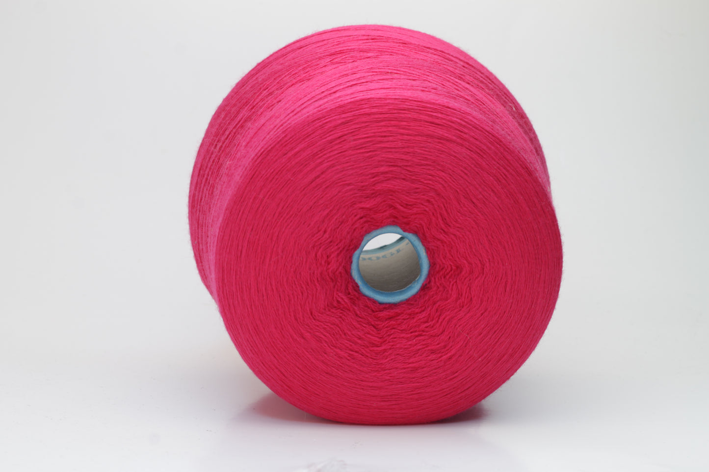 Close-up of vibrant fuchsia 100% merino yarn, showcasing a tight ply twist and a dense, fluffy texture with subtle sheen, perfect for intricate knit designs.