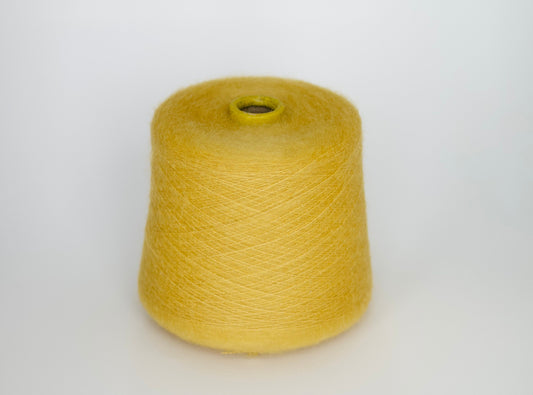 Close-up photograph of a cone of medium purple kid mohair and silk yarn, showcasing the fluffy fibers and subtle sheen. The ply twist is visible, creating a delicate thread structure with moderate fluffiness.